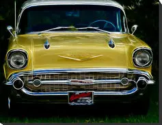 A yellow car with the hood up.